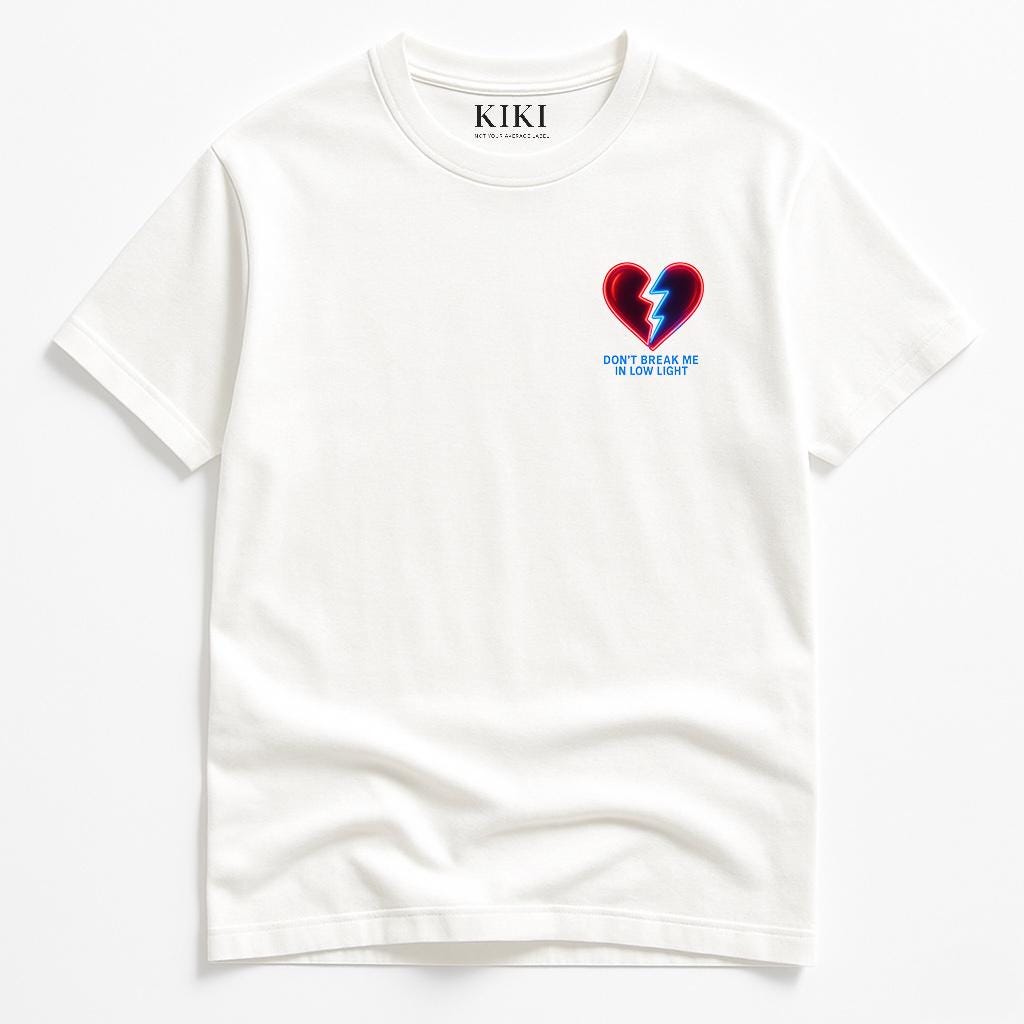 KIKI T-Shirt “Don’t Break Me In Low Light” – Maglietta Bianca Unisex con Stampa Grafica Cuore – Streetwear Artistico Made in Italy